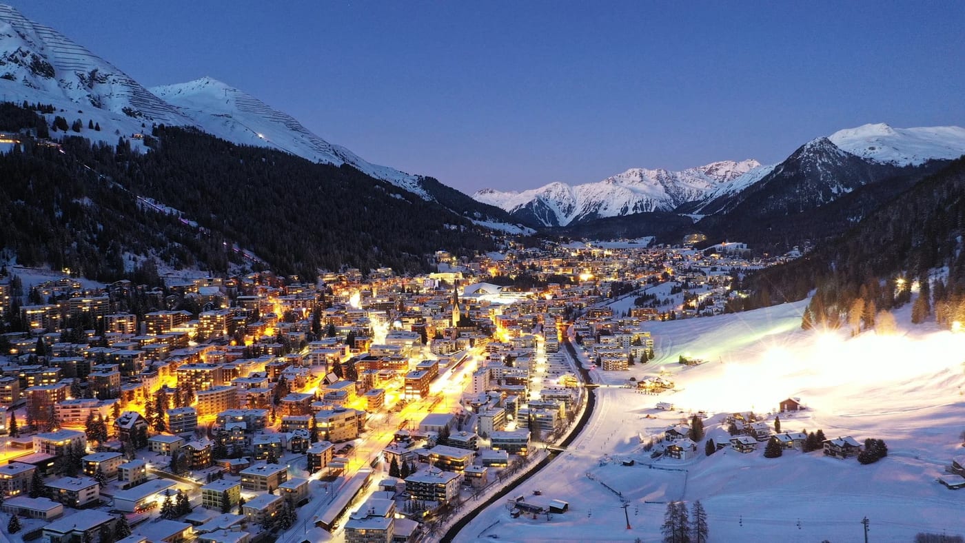 Davos bei Nacht, beleuchtet zwischen schneebedeckten Bergen